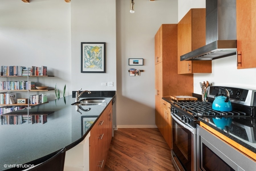 1040 West Adams Street, Unit 336 Chicago, IL 60607 - Photo 8 of 23 a kitchen with stainless steel appliances granite countertop a stove a sink and a refrigerator
