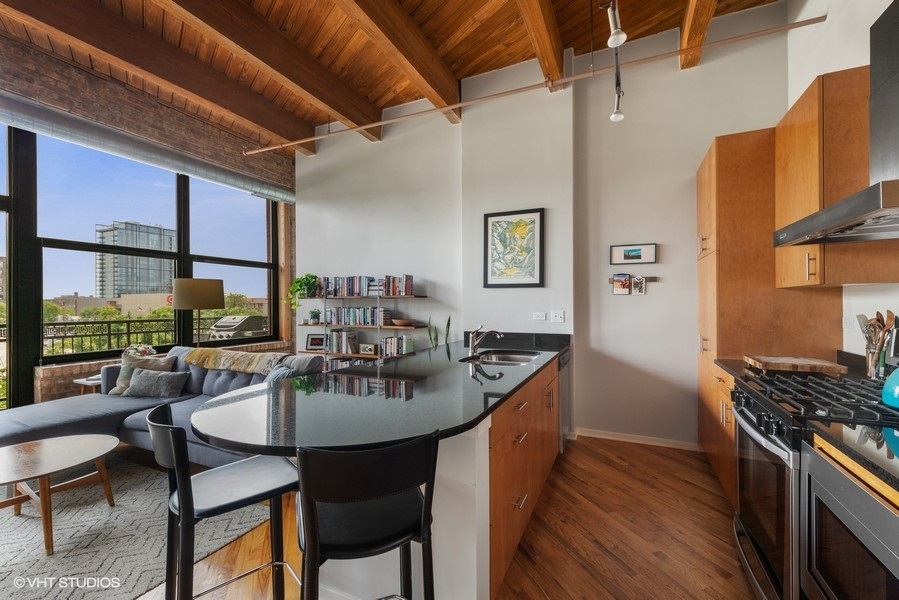 1040 West Adams Street, Unit 336 Chicago, IL 60607 - Photo 9 of 23 a kitchen with sink dining table and chairs