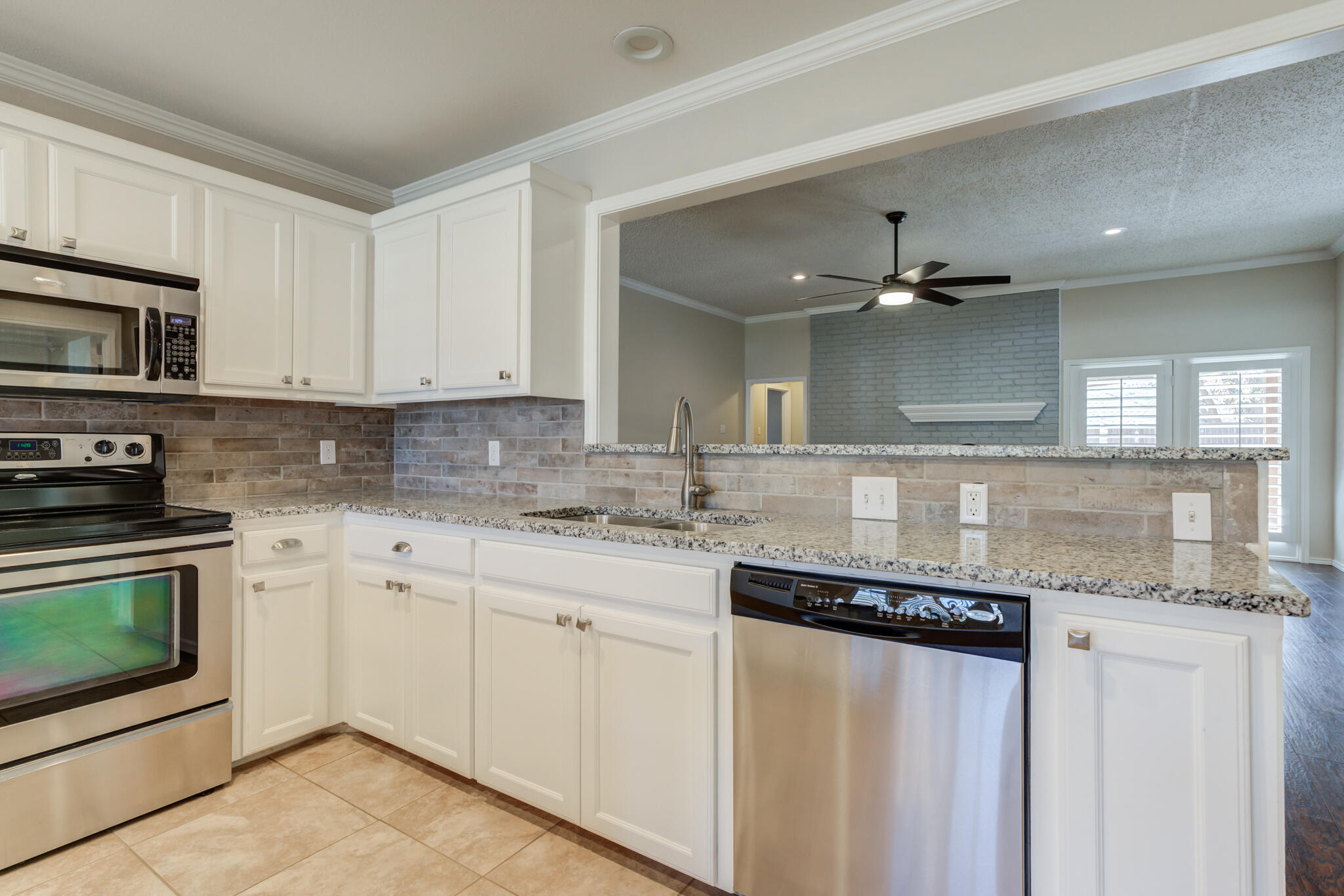 5407 68th Street Lubbock, TX 79424 - Photo 13 of 40 a kitchen with stainless steel appliances granite countertop a stove and a sink