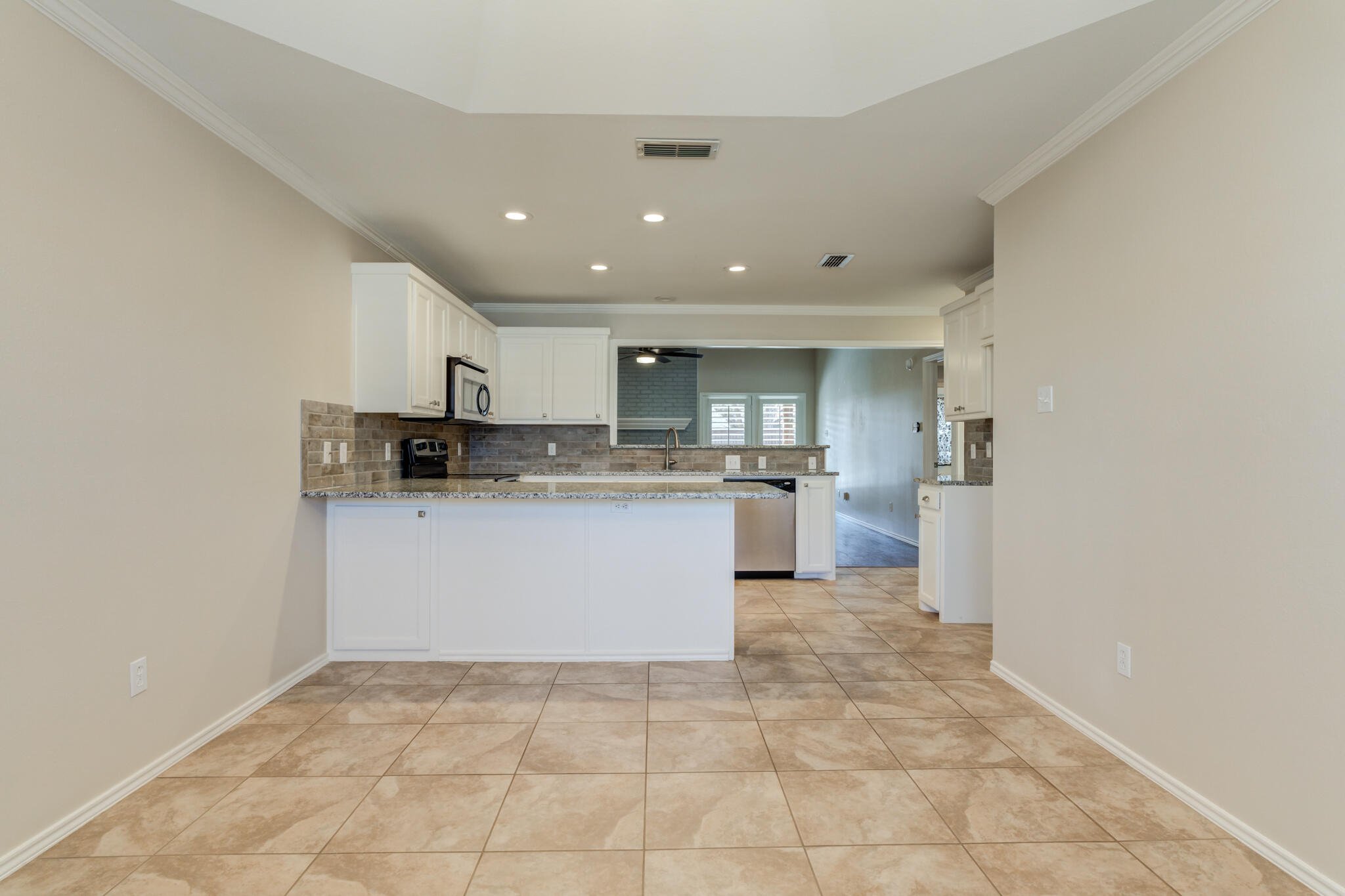 5407 68th Street Lubbock, TX 79424 - Photo 16 of 40 a large white kitchen with a sink