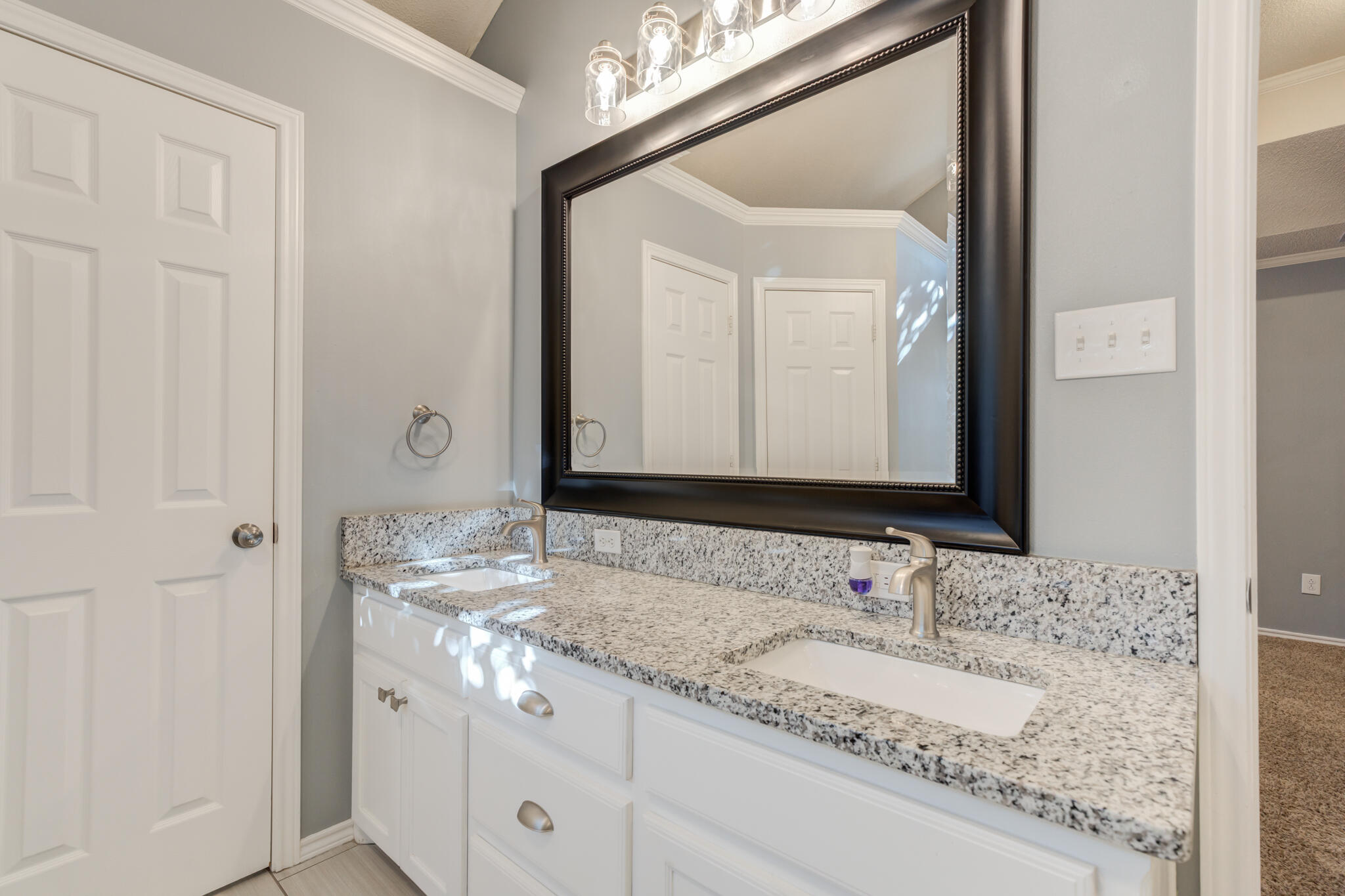 5407 68th Street Lubbock, TX 79424 - Photo 18 of 40 a bathroom with a granite countertop sink and a mirror