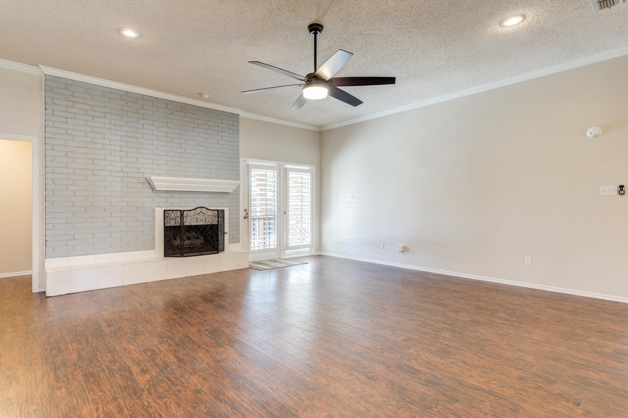 5407 68th Street Lubbock, TX 79424 - Photo 6 of 40 a view of empty room with fireplace and wooden floor