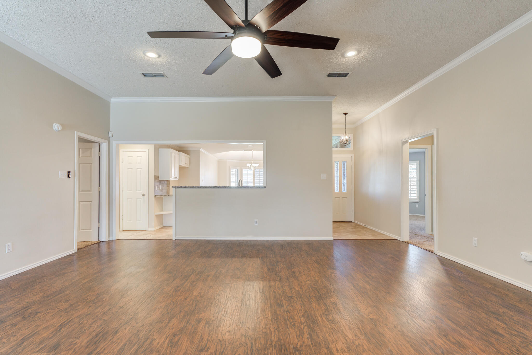 5407 68th Street Lubbock, TX 79424 - Photo 9 of 40 a view of an empty room with wooden floor and a ceiling fan