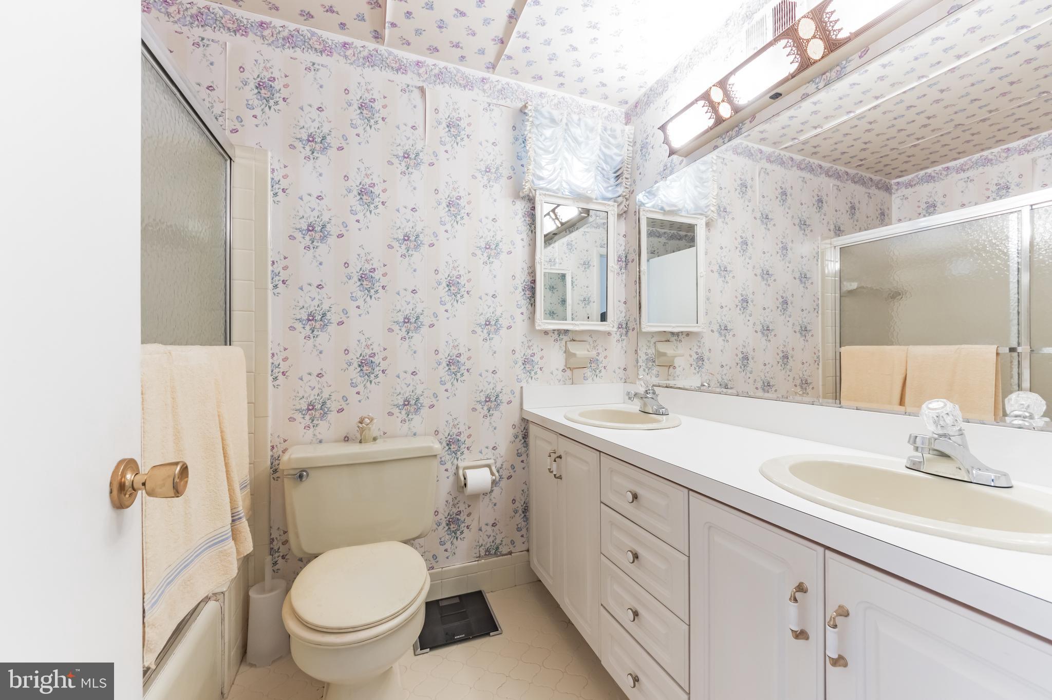9667 Pine Road Philadelphia, PA 19115 - Photo 23 of 30 a bathroom with a granite countertop toilet a sink and a mirror
