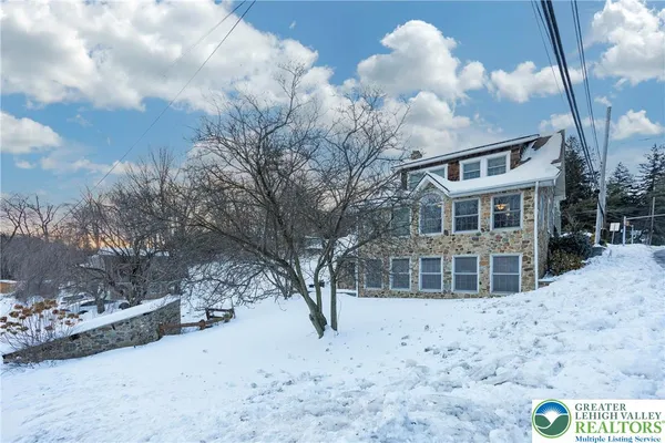 a front view of a building with large trees