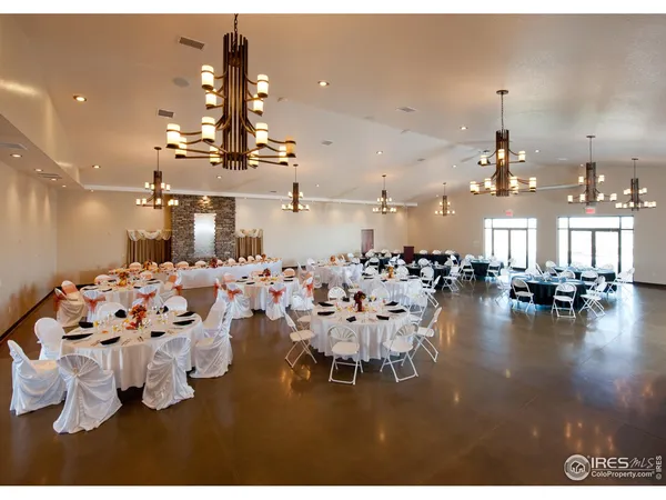 a living room with lots of white furniture and a chandelier