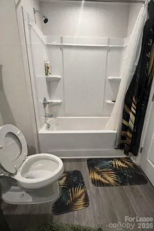 a bathroom with a toilet and a shower