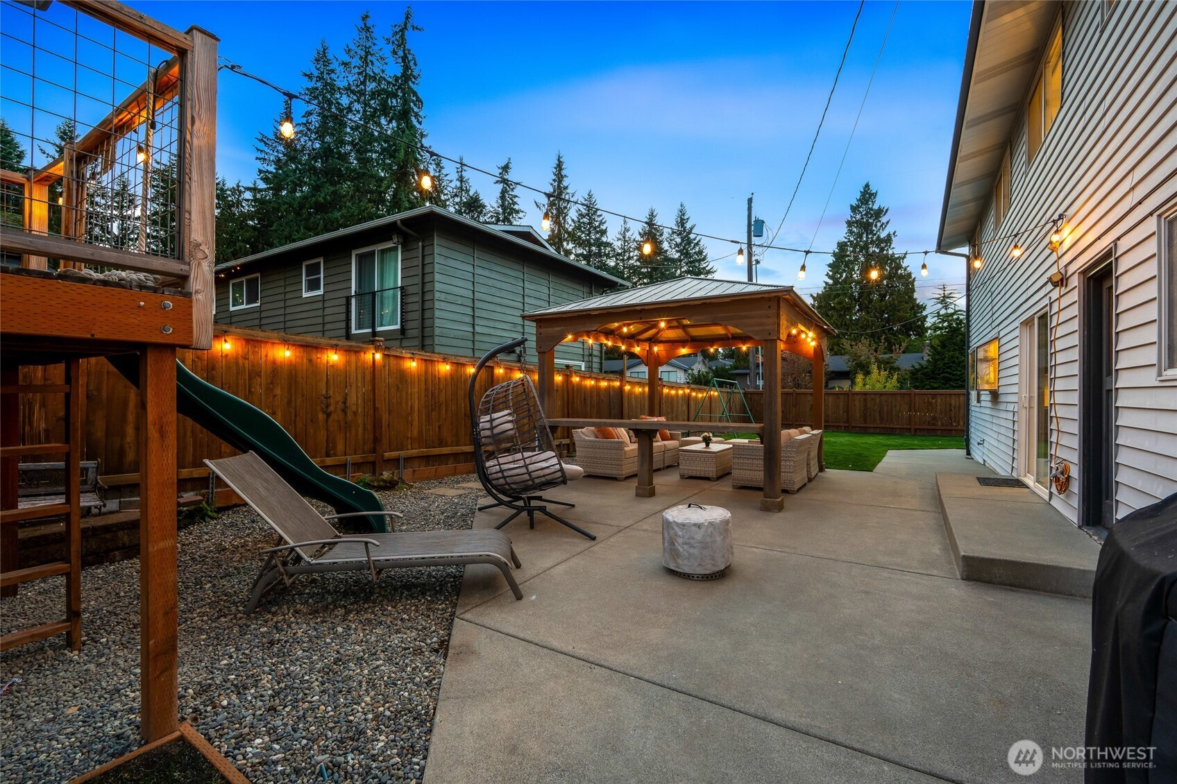 8804 209th Place Southwest Edmonds, WA 98026 - Photo 26 of 35 a view of a patio with table and chairs under an umbrella with a small yard