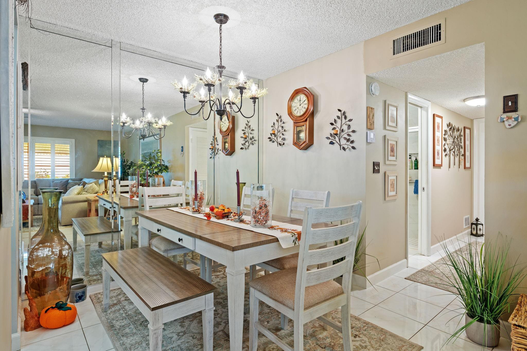 152 High Point Boulevard, Unit D Delray Beach, FL 33445 - Photo 12 of 34 a view of a dining room and livingroom with furniture wooden floor and a chandelier
