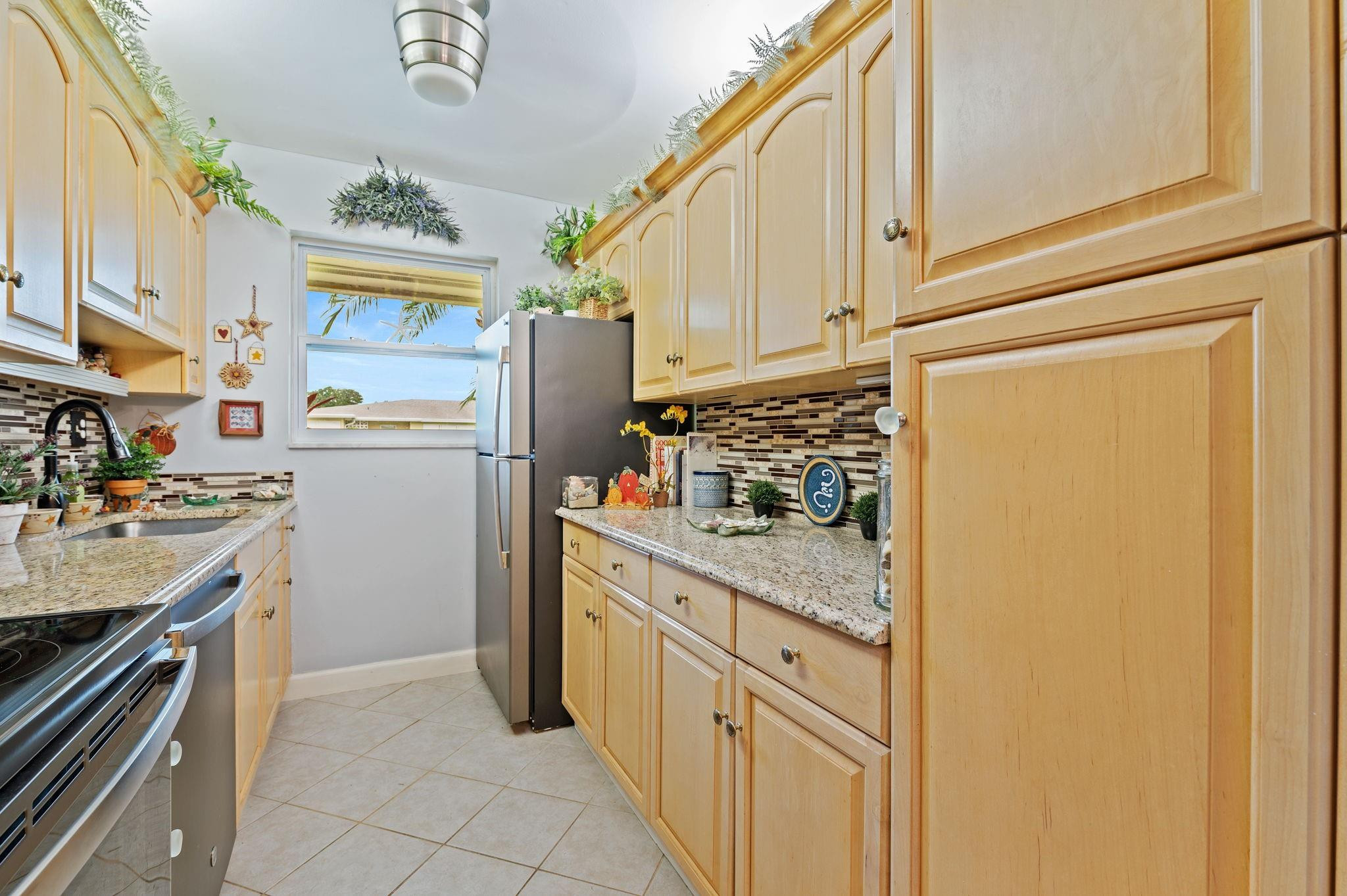 152 High Point Boulevard, Unit D Delray Beach, FL 33445 - Photo 16 of 34 a kitchen with stainless steel appliances granite countertop a refrigerator a stove and a sink