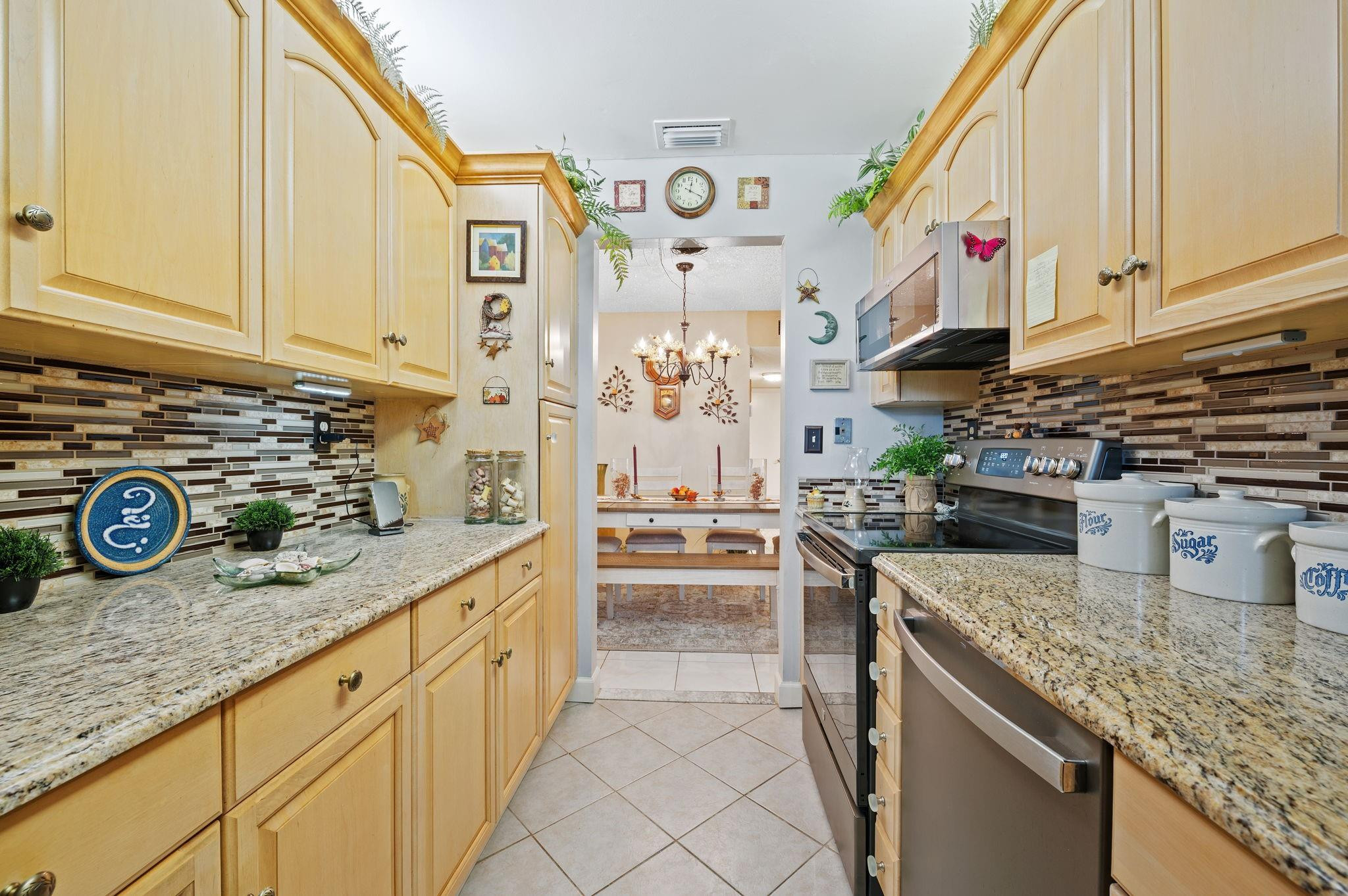 152 High Point Boulevard, Unit D Delray Beach, FL 33445 - Photo 17 of 34 a kitchen with stainless steel appliances granite countertop a stove and a sink