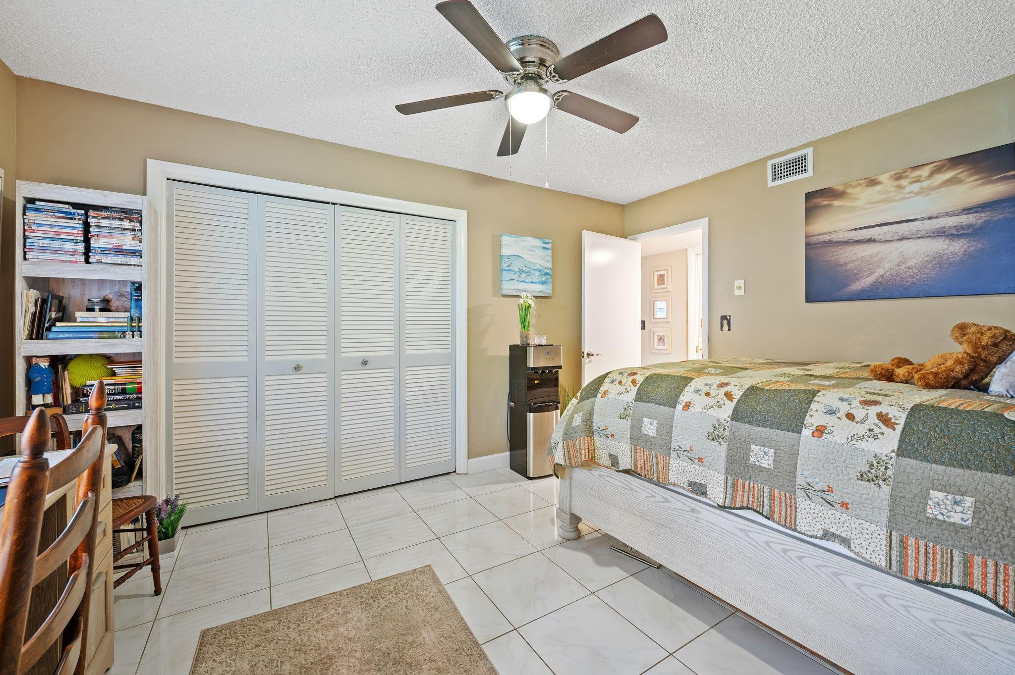 152 High Point Boulevard, Unit D Delray Beach, FL 33445 - Photo 19 of 34 a bedroom with a bed and a walk in closet