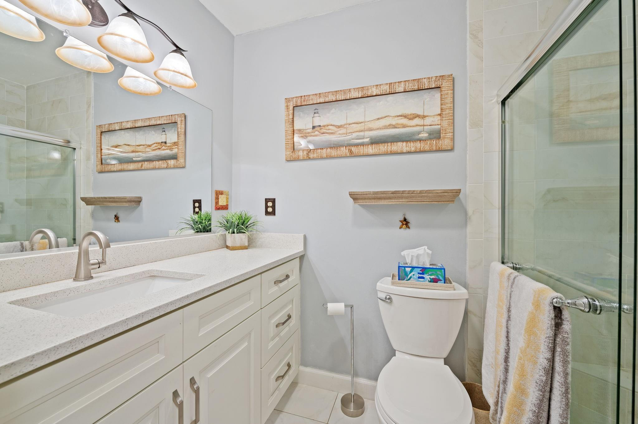 152 High Point Boulevard, Unit D Delray Beach, FL 33445 - Photo 20 of 34 a bathroom with a sink a mirror and a toilet
