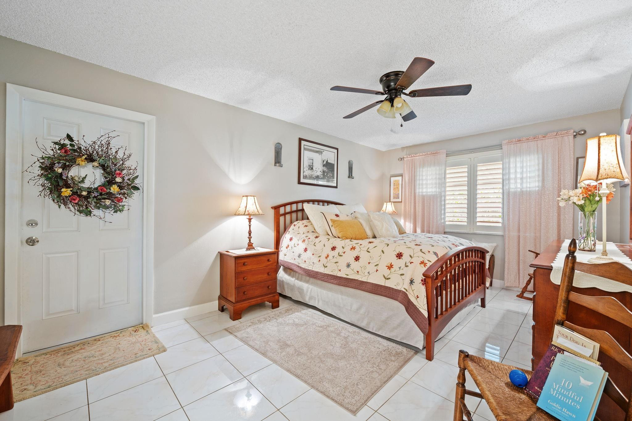 152 High Point Boulevard, Unit D Delray Beach, FL 33445 - Photo 22 of 34 a bedroom with a bed and a chandelier