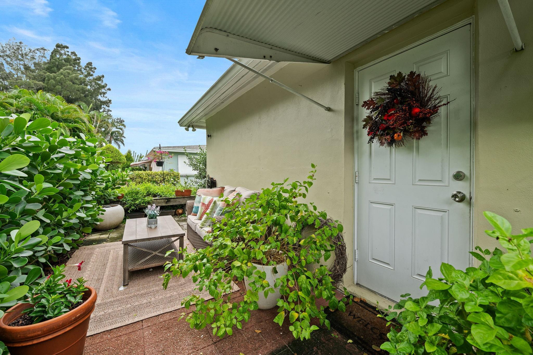 152 High Point Boulevard, Unit D Delray Beach, FL 33445 - Photo 26 of 34 front view of a house with a flower garden