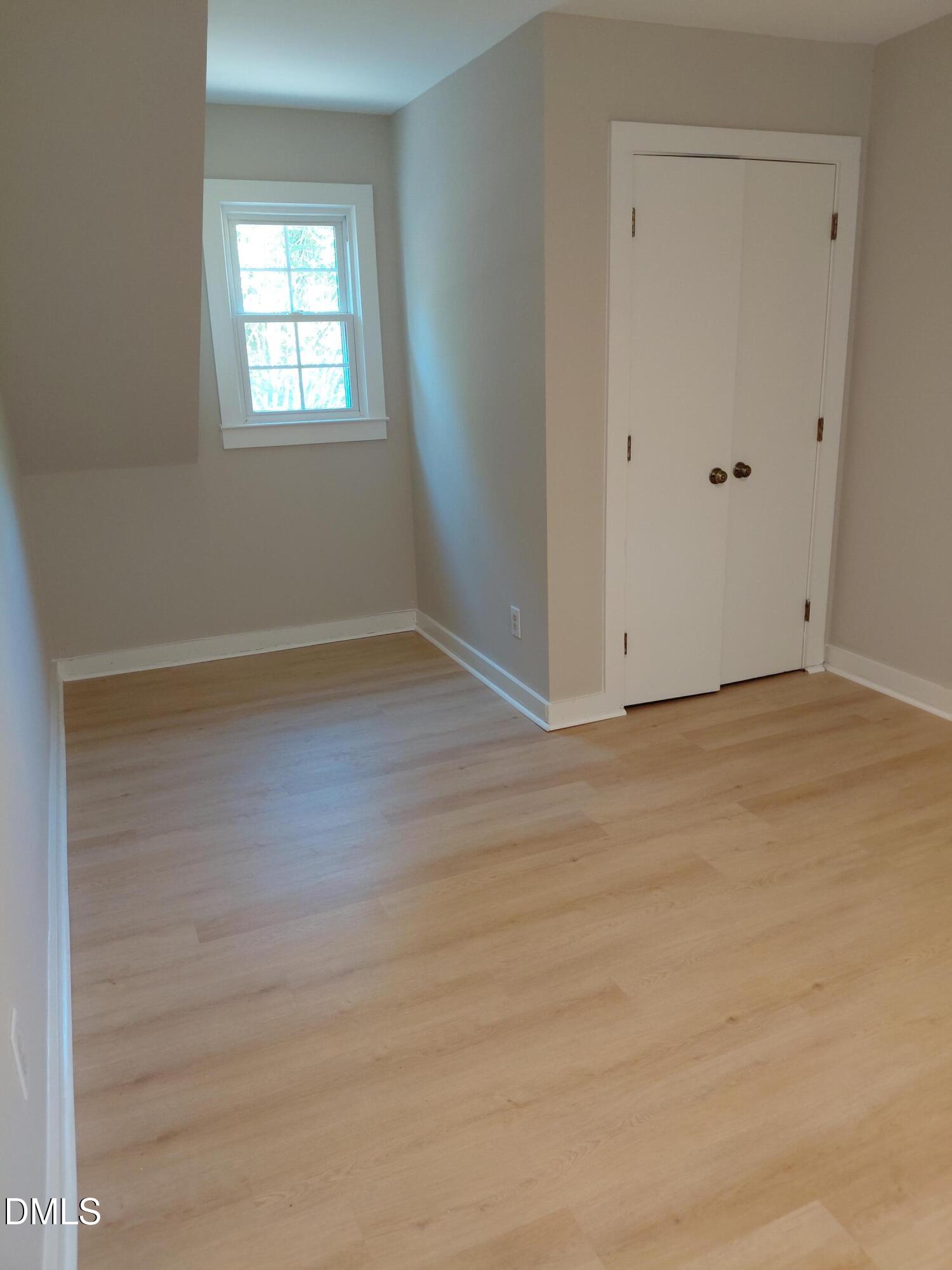804 Olive Street Apex, NC 27502 - Photo 44 of 60 an empty room with wooden floor and windows
