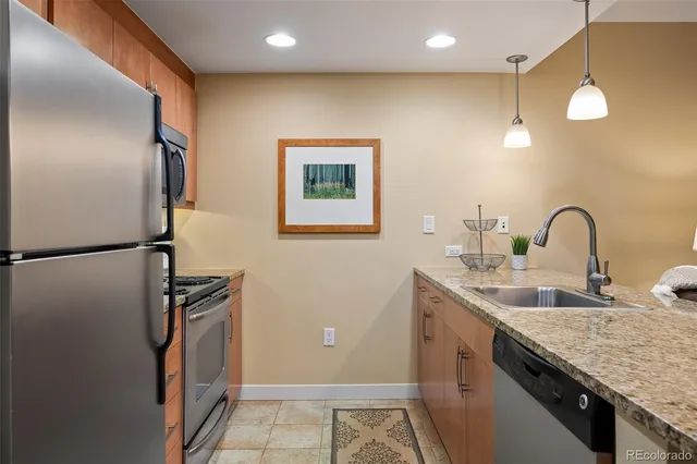 a kitchen with stainless steel appliances granite countertop a sink and a refrigerator