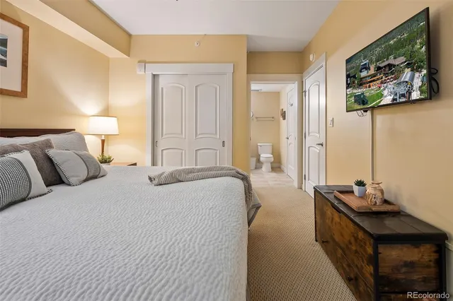 a bedroom with a bed and a painting on the wall