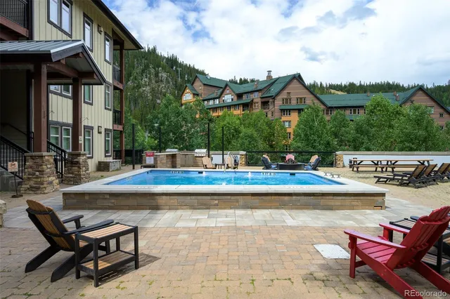 a view of a swimming pool with lawn chairs and couches