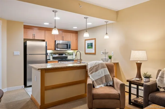 a kitchen with stainless steel appliances granite countertop a refrigerator and a stove top oven