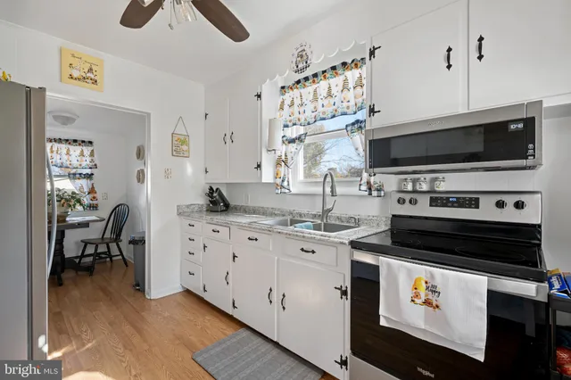 a kitchen with stainless steel appliances a stove sink microwave and cabinets