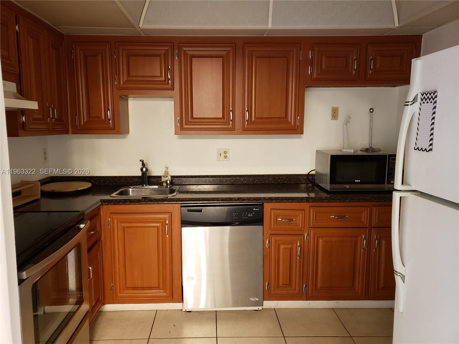4170 Inverrary Drive, Unit 310 Lauderhill, FL 33319 - Photo 1 of 10 a kitchen with stainless steel appliances granite countertop a stove and a refrigerator