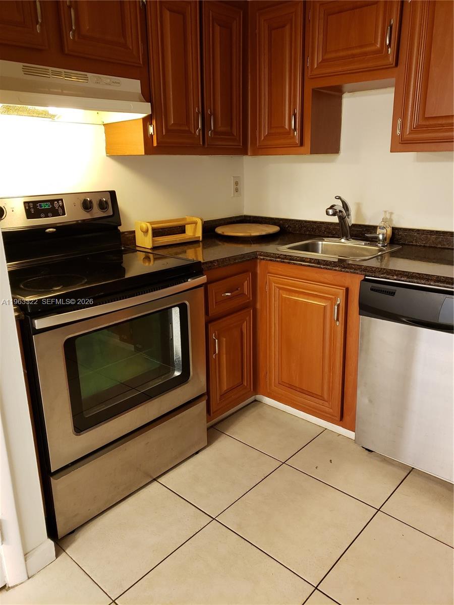4170 Inverrary Drive, Unit 310 Lauderhill, FL 33319 - Photo 2 of 10 a kitchen with granite countertop a stove top oven microwave and cabinets
