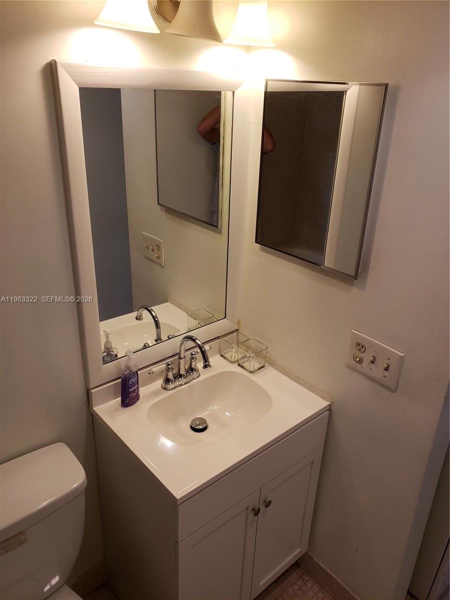 4170 Inverrary Drive, Unit 310 Lauderhill, FL 33319 - Photo 9 of 10 a bathroom with a sink toilet and mirror