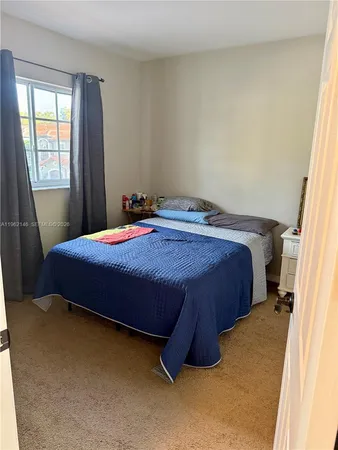 a view of a backyard with wooden fence and a bench