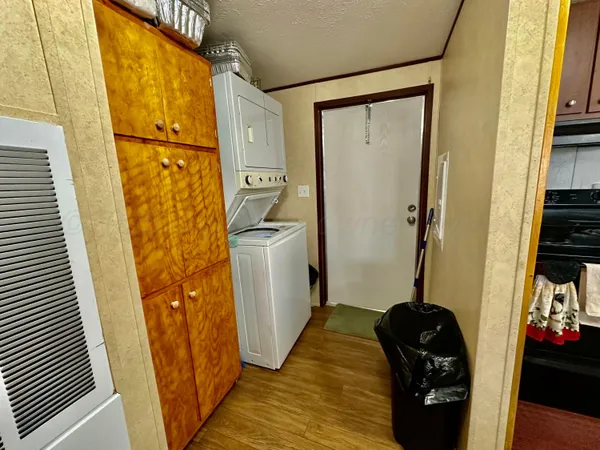 a view of a hallway with a door and wooden floor