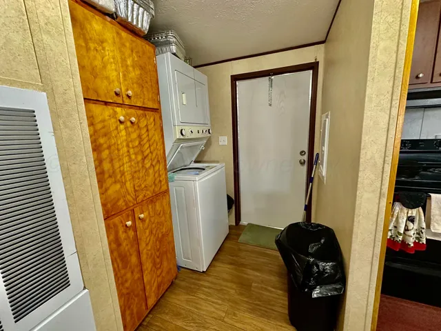a view of a hallway with a door and wooden floor