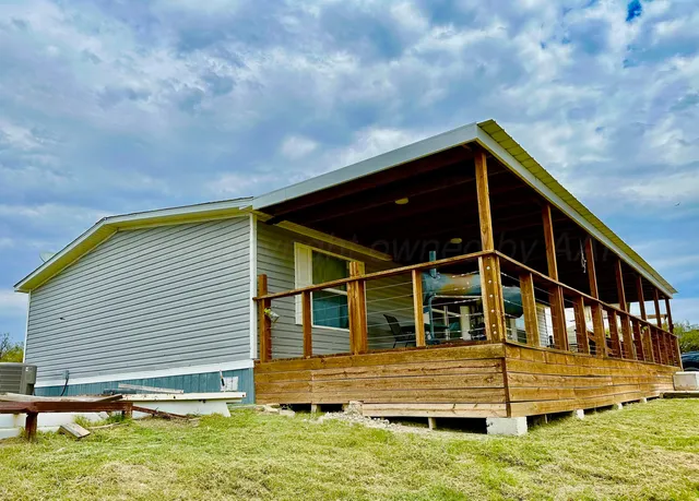 a view of house with backyard and balcony