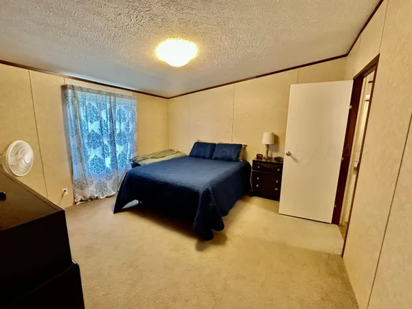 a living room with a bed furniture and a large window