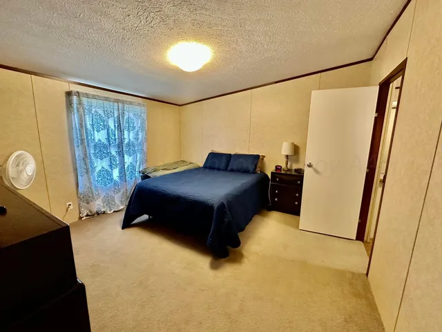 a living room with a bed furniture and a large window