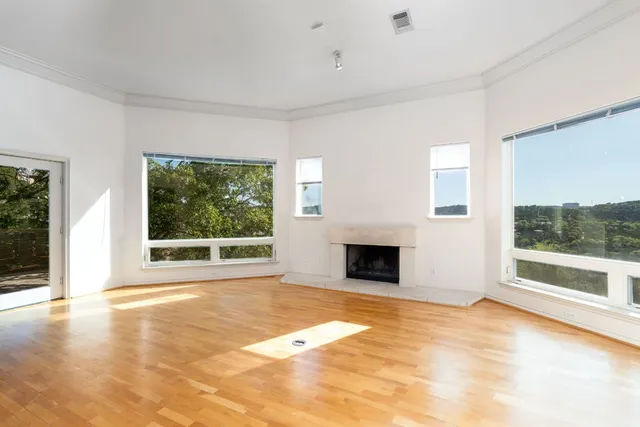 a view of empty room with a fireplace and window