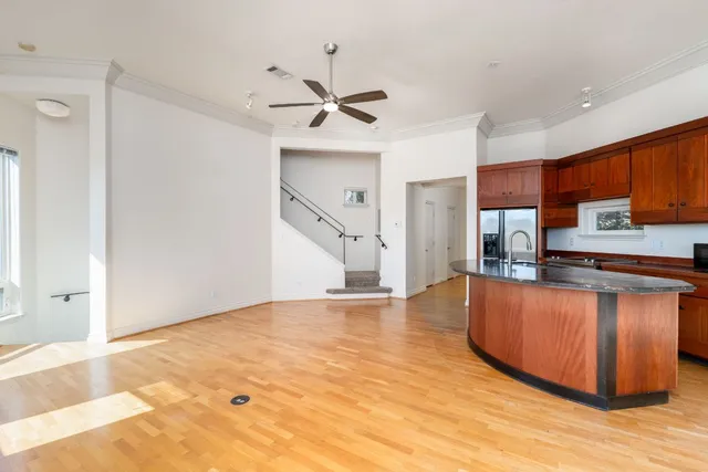 a view of kitchen with stainless steel appliances refrigerator stove and wooden floor