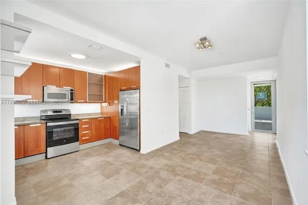 a kitchen with stainless steel appliances granite countertop a stove a sink and a refrigerator