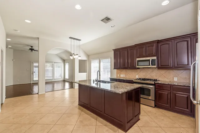 a kitchen with stainless steel appliances granite countertop a sink counter space cabinets and a large window