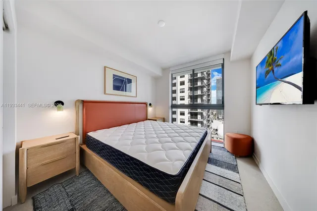 a bedroom with a bed and a flat screen tv