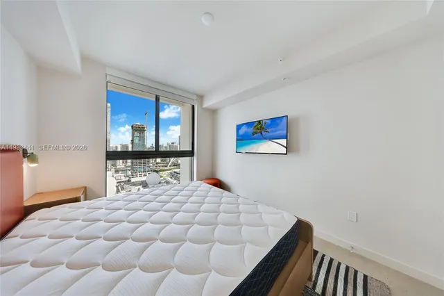 a bedroom with a bed and a flat screen tv