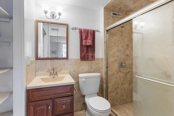 a bathroom with a toilet a sink and mirror