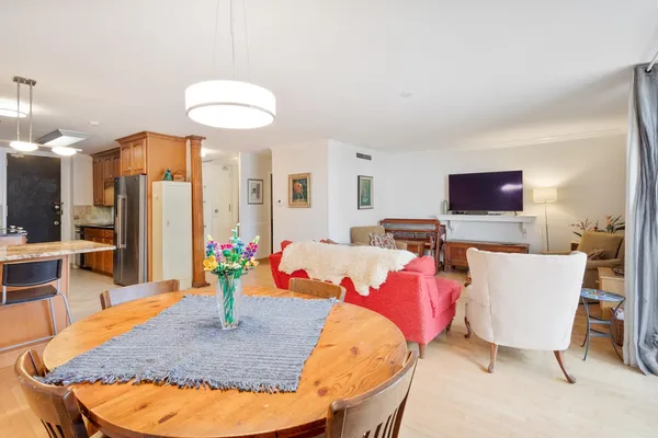 a living room with furniture a flat screen tv and kitchen view
