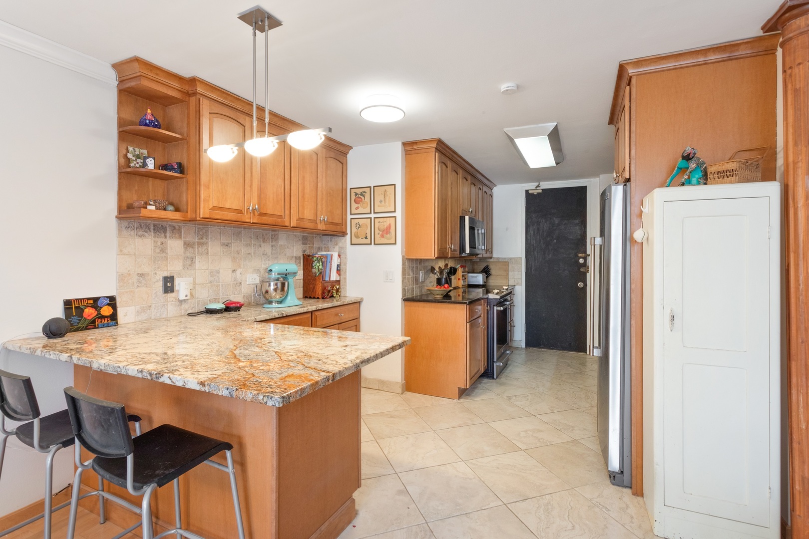 5901 North Sheridan Road, Unit 2K Chicago, IL 60660 - Photo 9 of 27 a kitchen with kitchen island a stove a sink a refrigerator and a refrigerator