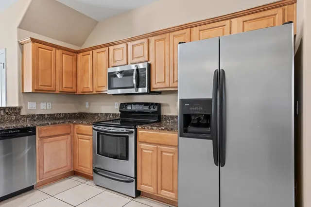 a kitchen with stainless steel appliances granite countertop a refrigerator stove and microwave