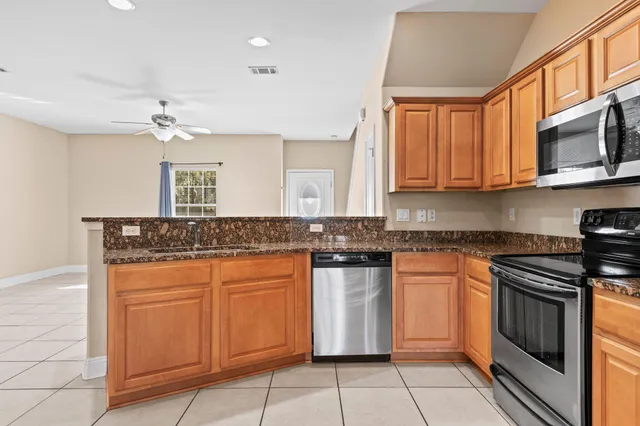 a kitchen with stainless steel appliances granite countertop a stove sink and cabinets