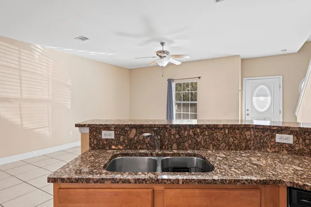 a kitchen with granite countertop a sink a counter top space and cabinets