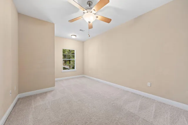 an empty room with a window and a fan