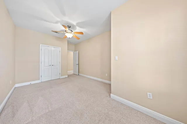 an empty room with a ceiling fan and a window