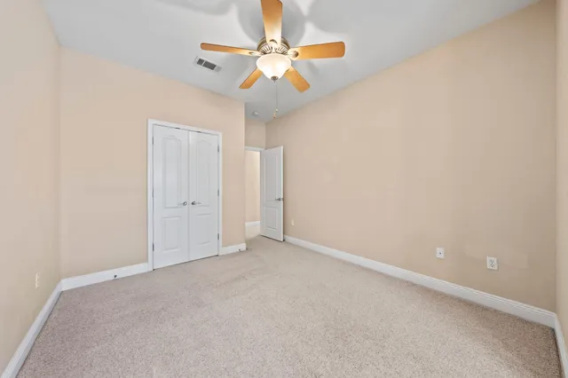 an empty room with chandelier fan