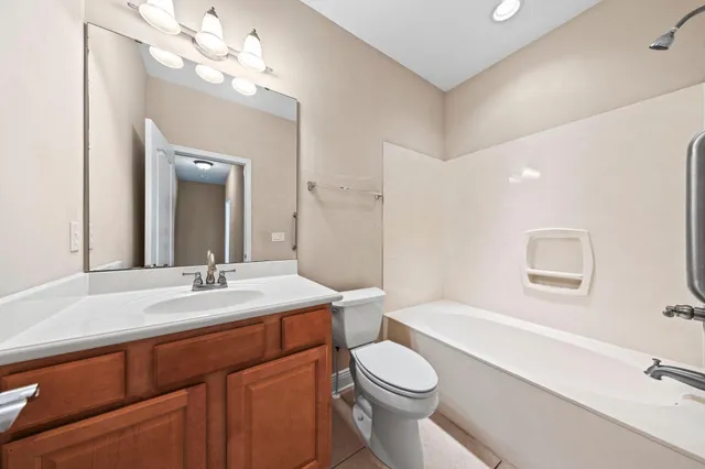 a bathroom with a toilet a sink a tub and a mirror